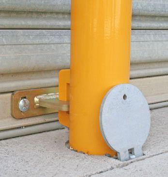 Removable bollard secured to roller door